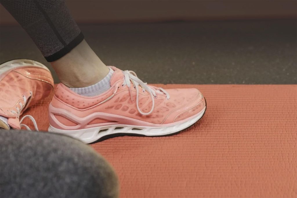 Ténis cor-de-rosa sobre um tapete de exercício durante uma sessão de atividade física